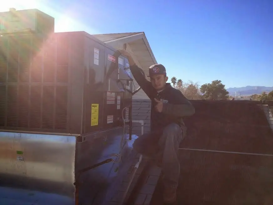 HVAC technician performing Boiler Repair on a rooftop unit in Parker